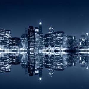 Нощен силует на мегаполис с отражение във водата