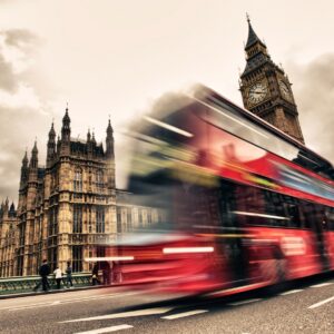 Червен автобус в движение пред Биг Бен в Лондон