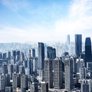 Панорамна фотография на модерен град с небостъргачи и синьо небе