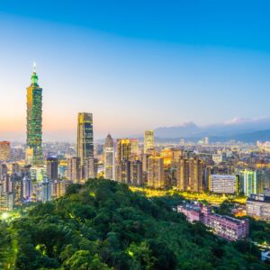 Тайпе 101 и градски пейзаж при залез с топли тонове.