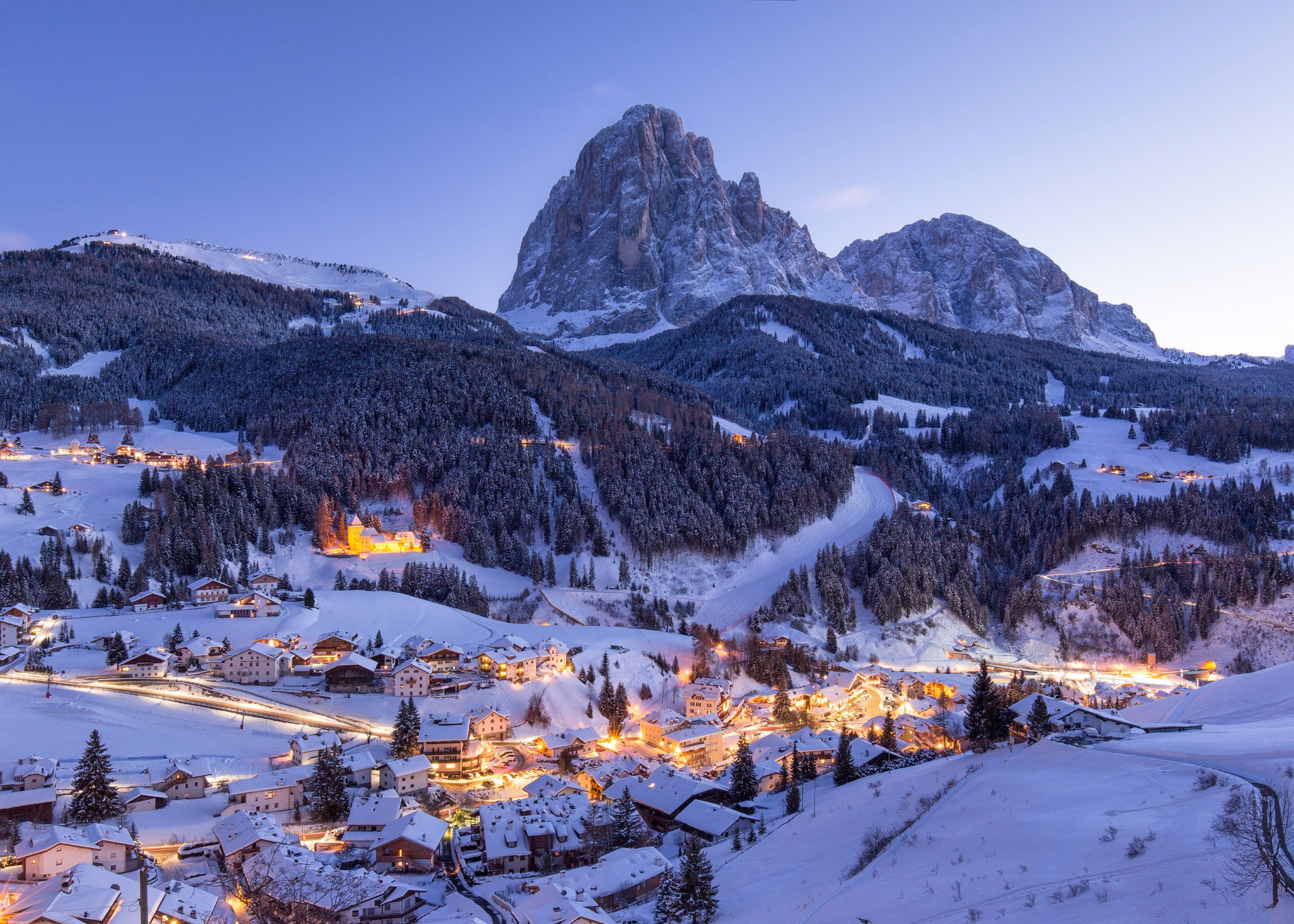 Заснежено алпийско градче с планина на заден фон.