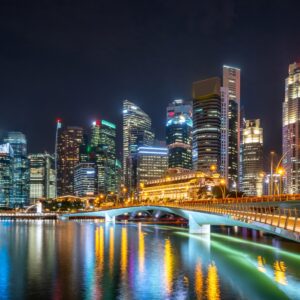 Панорамна фотография на Сингапур през нощта с осветени сгради и мост