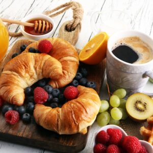 Закуска с кроасани, кафе и плодове