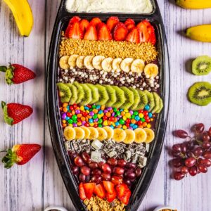 Плодова лодка с банани, ягоди и киви в артистична подредба