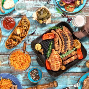 Традиционна скара с месо, зеленчуци и сосове върху синя маса