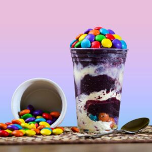 Десерт с цветни дражета върху розово-син фон