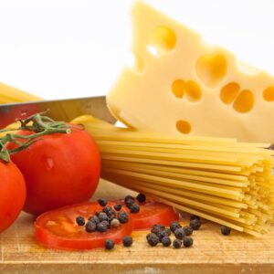 Паста със сирене и домати върху дървена дъска