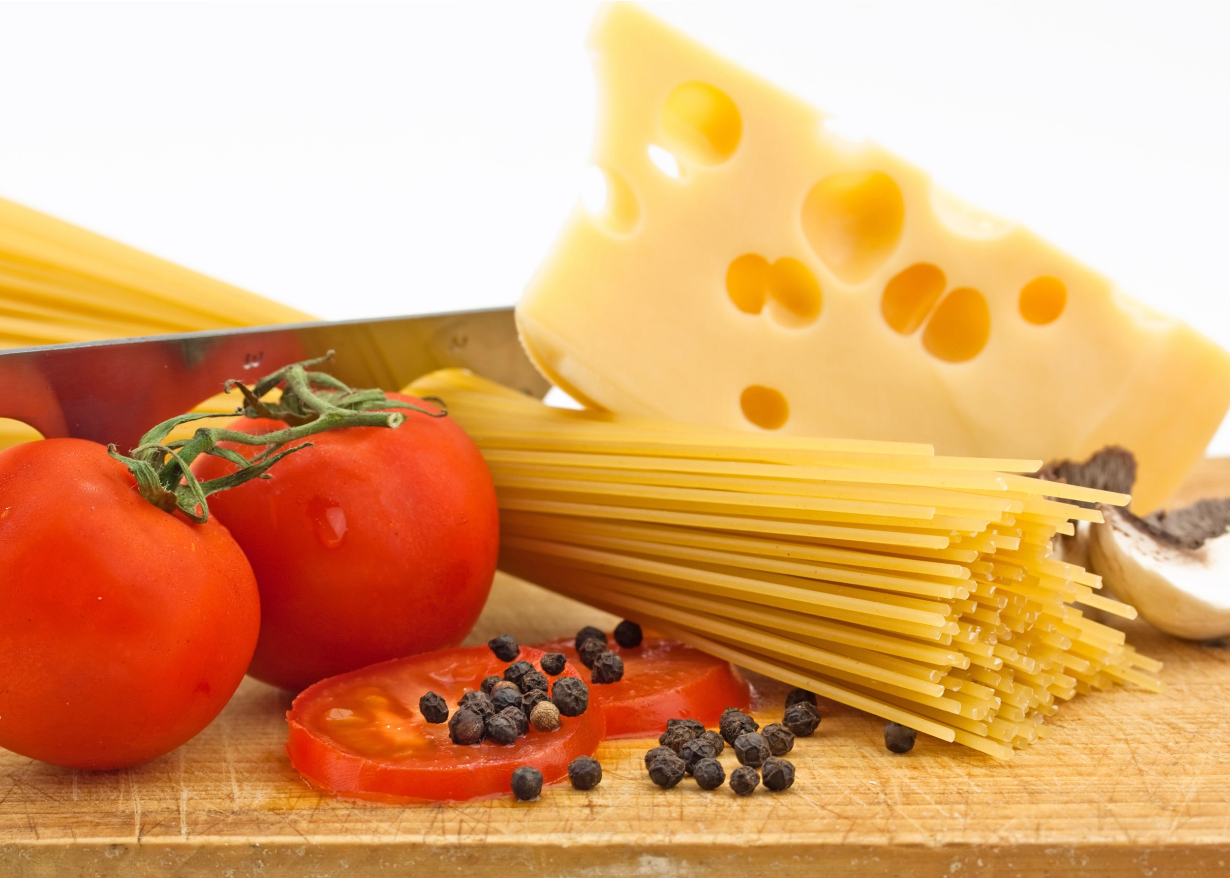 Паста със сирене и домати върху дървена дъска