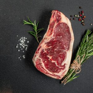 Суров стек с розмарин и сол върху тъмен фон