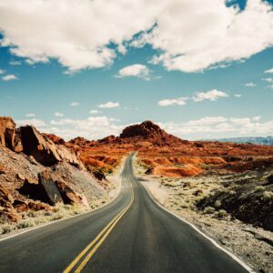 Път през червен пустинен пейзаж със синьо небе