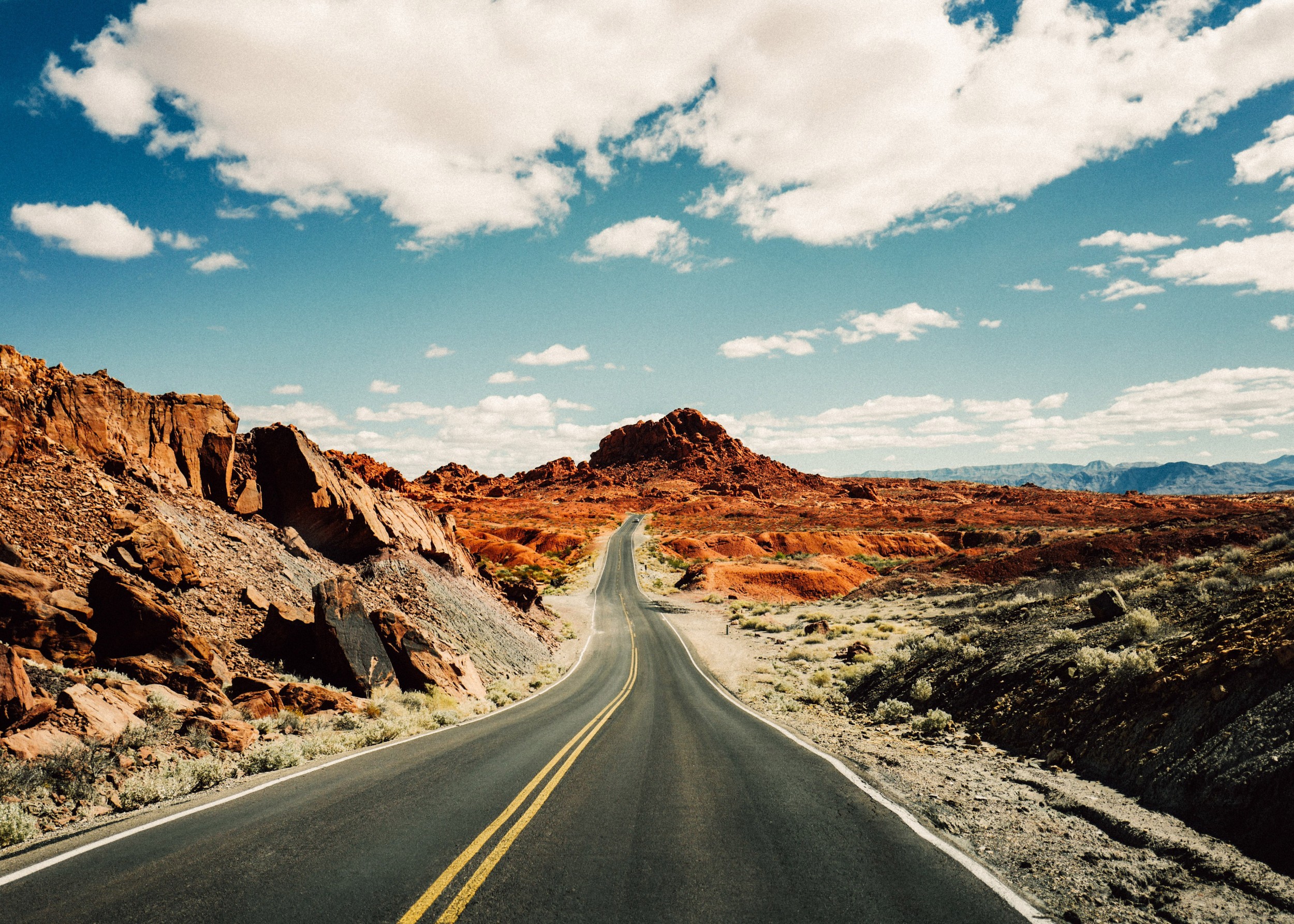 Път през червен пустинен пейзаж със синьо небе