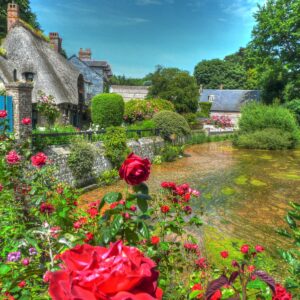 Селска къща с рози и река в идилична обстановка