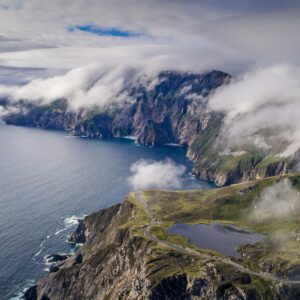 Скалисто крайбрежие с облаци и планини