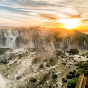 Водопадите Игуасу при залез с оранжево небе и мъгла.
