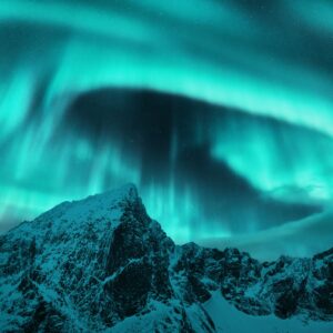 Северно сияние над планина през нощта.