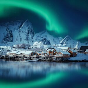 Северно сияние над рибарско селище и планини.