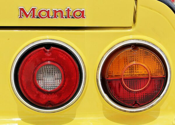 Opel Manta със задни светлини в червено и оранжево върху жълта каросерия