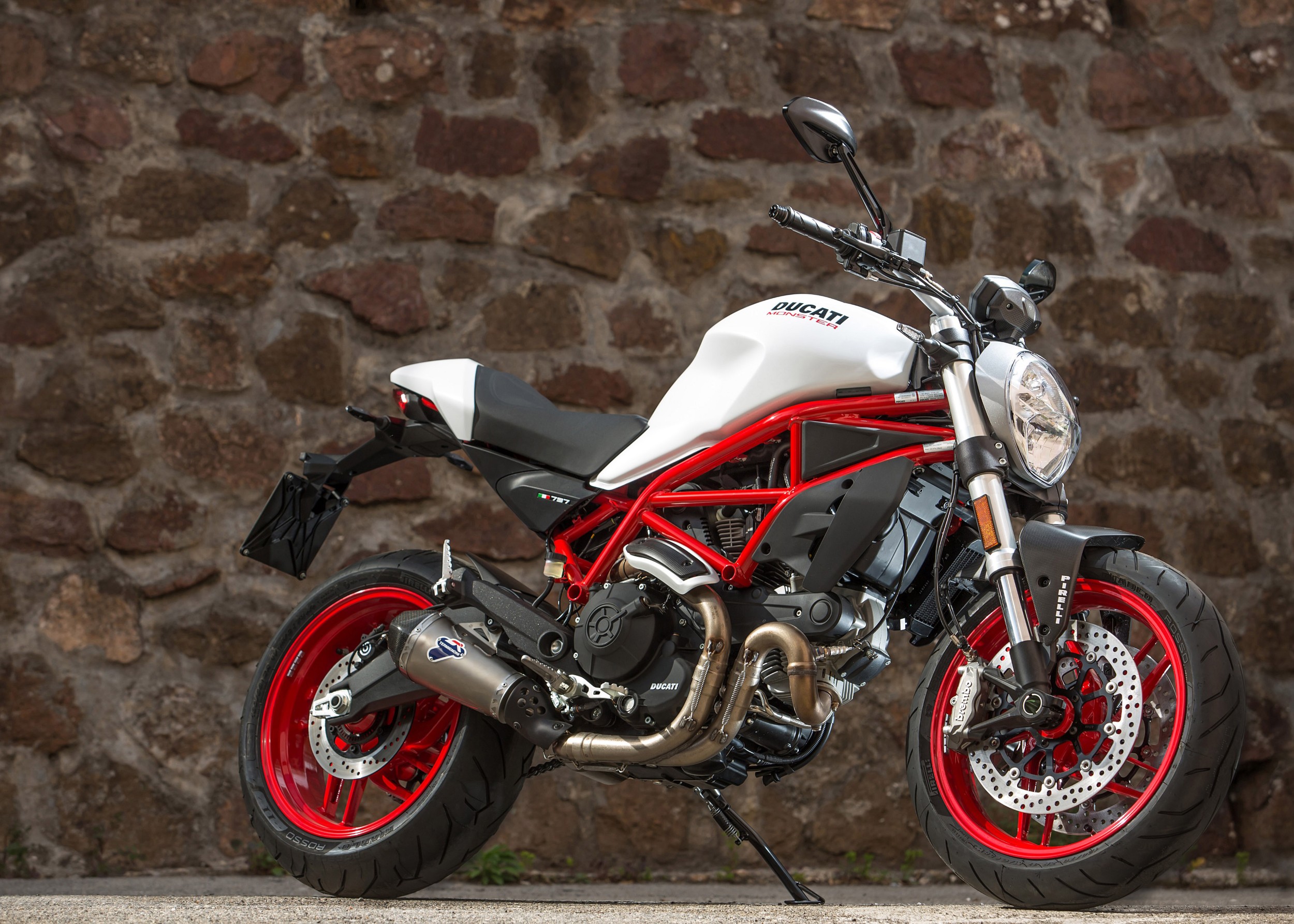 Ducati Monster в бяло и червено пред каменна стена