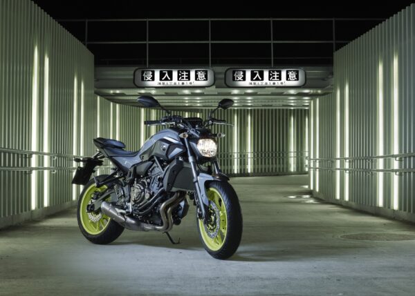 Yamaha мотоциклет с жълти джанти в индустриална светлинна среда