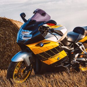 BMW мотор с жълто-черна спортна графика до сламена бала