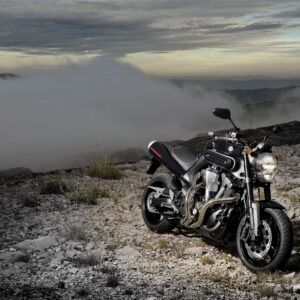 Мотоциклет на скалист планински терен с облаци