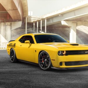 Yellow Dodge Challenger muscle car under highway bridge