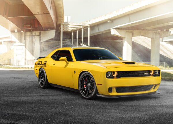 Yellow Dodge Challenger muscle car under highway bridge