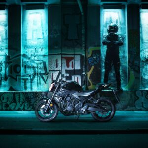 Motorcycle in neon blue light under graffiti wall