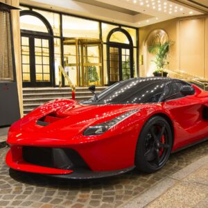 Червена Ferrari LaFerrari пред входа на луксозен хотел