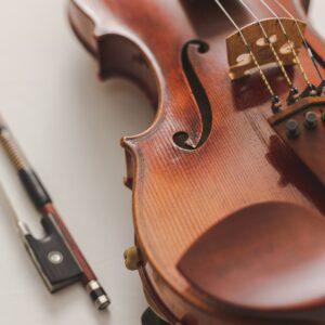 Цигулка и лък върху светъл фон