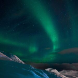 Северно сияние над снежни хълмове и нощно небе