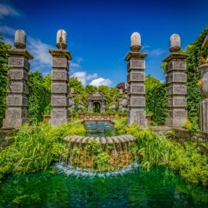 Фонтан в градина с колони и зеленина