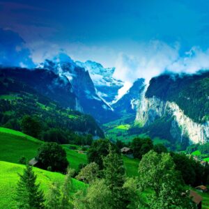 Алпийска долина със зелени хълмове и снежни върхове