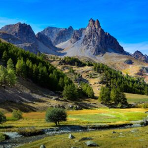 Алпийски върхове и зелени долини под синьо небе