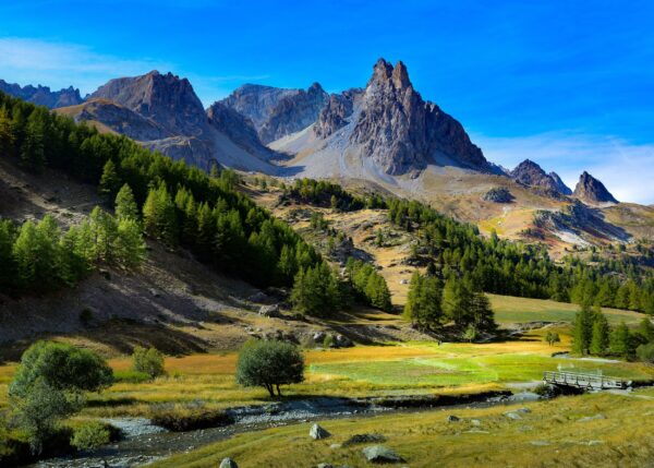 Алпийски върхове и зелени долини под синьо небе