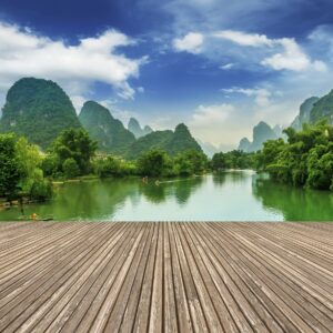 Река сред зелени планини с дървена тераса на преден план