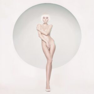 Жена с къса руса коса позира в бял кръг