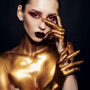 Жена със златно тяло и драматичен грим.