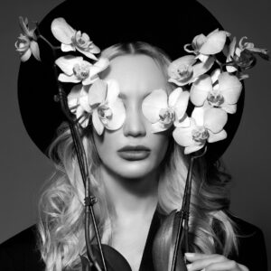 Жена с орхидеи и черна шапка
