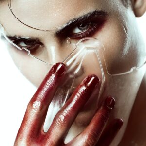 Man with red paint hands and transparent mask.