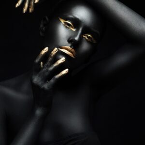 Artistic portrait of a woman with black skin and golden highlights.