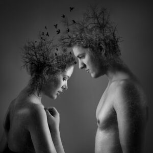 Conceptual black and white portrait of man and woman with nature elements.