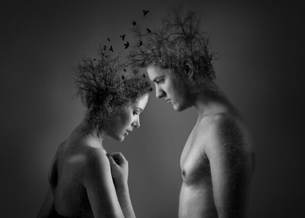 Conceptual black and white portrait of man and woman with nature elements.