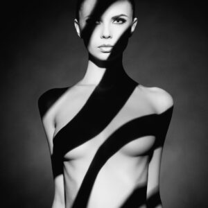 Актова художествена фотография в черно-бяло със светлинни сенки.