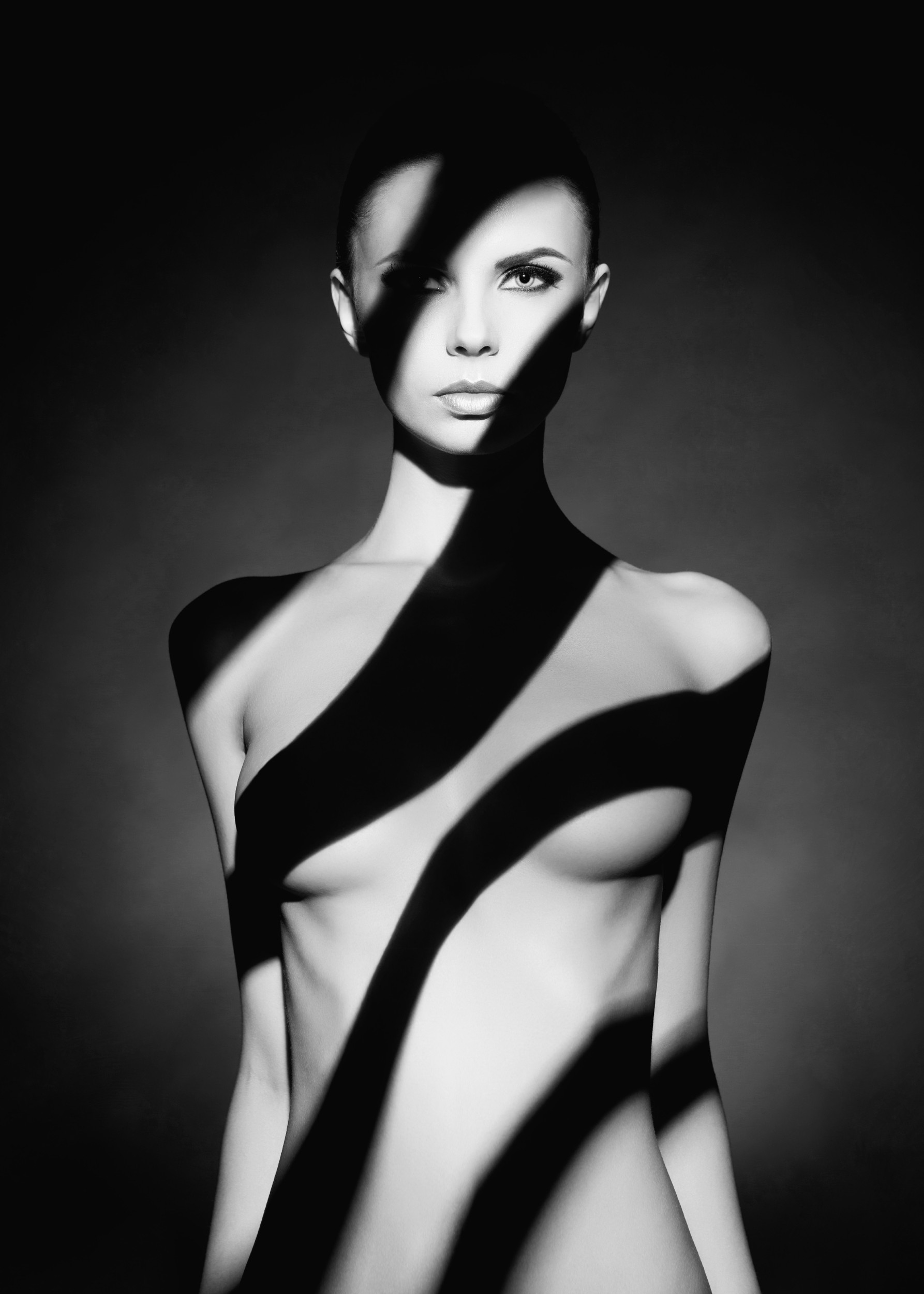 Актова художествена фотография в черно-бяло със светлинни сенки.