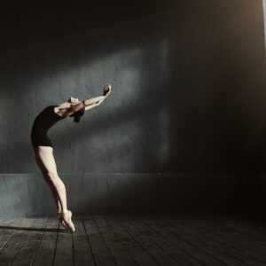 Балерина изпълнява артистичен скок в празна зала – фотография с емоция.