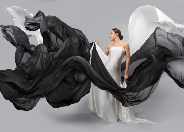 Modern black and white photo of a woman with flowing veils in elegant composition.