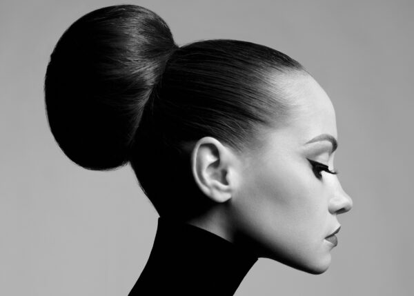 Black and white profile portrait of a woman with elegant bun.