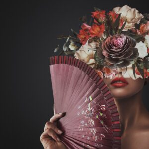 Жена с червен ветрило и цветна украса на главата