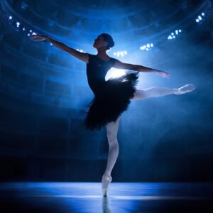 Балерина в черен костюм на театрална сцена